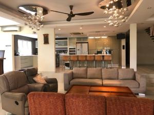 ein Wohnzimmer mit einem Sofa und einem Tisch in der Unterkunft Bangsar Grande Villa 23 by Vale Pine in Kuala Lumpur