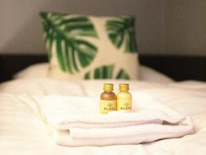 two bottles of essential oils sitting on top of a bed at The Cavern Apartment @ Liver House in Rock Ferry