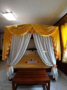een slaapkamer met een hemelbed en een houten tafel bij Hof Gorei Beach Resort Davao in Samal