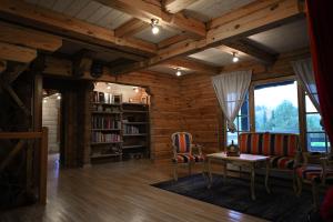 sala de estar con techos de madera, mesa y sillas en Spacious house with stunning views and sauna in Amatciems, en Amata