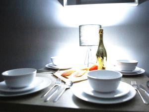 a table with plates and forks and a bottle of champagne at John's Studio @ Liver House in Rock Ferry