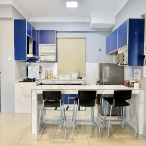 a kitchen with blue cabinets and bar stools at Casahome by Irdina Meru- 8pax -10pax in Ipoh