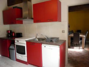 uma cozinha com armários vermelhos e um lavatório em Gîte Les-Villages-Vovéens, 5 pièces, 12 personnes - FR-1-581-63 