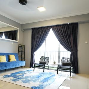 uma sala de estar com um sofá e cadeiras azuis e uma grande janela em Casahome by Irdina Meru- 8pax -10pax em Ipoh