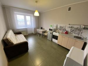 a living room with a couch and a kitchen at Dekabrist Apartment at Kirova 16 in Chita