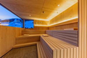 a sauna with a large window in a wooden building at m3Hotel in Sankt Anton am Arlberg