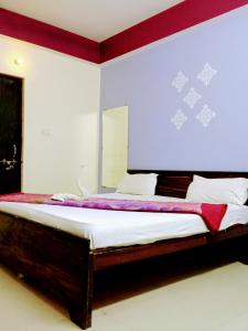 - une chambre dotée d'un grand lit avec un mur violet et blanc dans l'établissement The Shivay Guest House, à Varanasi