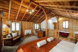 a bedroom with a large bed and a bath tub at Hotel Mas de la Coutettaz, The Farmhouse in Morzine