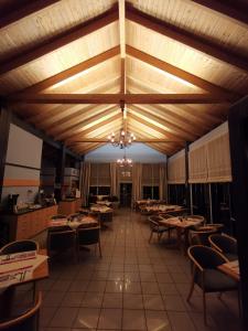 a restaurant with wooden ceilings and tables and chairs at REGIOHOTEL Wittekind Burg in Burg bei Magdeburg