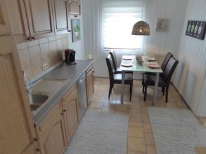 a kitchen with a table and chairs and a sink at Ambiente Ferienapartments Julienhöhe in Niederdorf