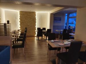 a restaurant with tables and chairs and a brick wall at Hotel Waldrausch in Hahnenklee-Bockswiese