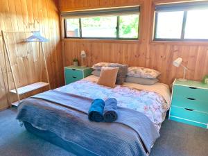 a bedroom with a bed with blue slippers on it at No43 Studio apartment in Mount Beauty