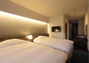 two beds in a hotel room with white sheets at Karasuma Rokujo Hotel / Vacation STAY 3036 in Kyoto