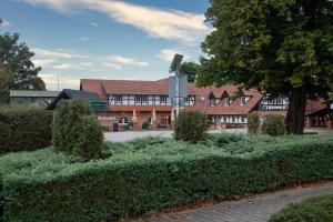 a building with bushes in front of a building at Ritterhof Kampehl in Neustadt