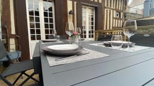 a table with plates and wine glasses on a balcony at Honfleur effet mer 2 in Honfleur +29 photos