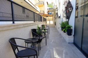 une rangée de chaises et de tables sur un balcon dans l'établissement Ozgur City Residence, à Fethiye