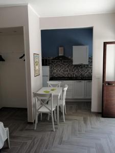 a dining room with a white table and chairs at Casacecilia relax in Siracusa