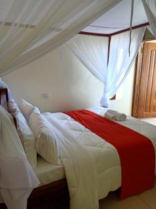 a bedroom with a large bed with a canopy at Turbine Ngong Hotel in Ngong