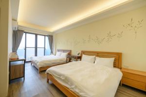 Habitación de hotel con 2 camas y ventana en Fengxianlu Herb Garden Homestay, en Magong
