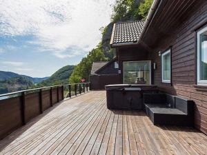 una gran terraza de madera con bañera en una casa en 10 person holiday home in lyngdal, en Lyngdal