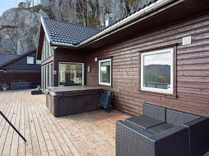 Casa de madera con terraza con bañera de hidromasaje en 10 person holiday home in lyngdal, en Lyngdal