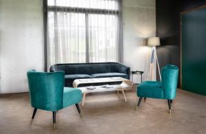 salon z kanapą i 2 krzesłami w obiekcie Wyna Motel w mieście Neudorf