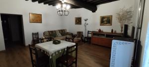 sala de estar con sofá, mesa y TV en Casa Fuente la Calle, en San Martín del Castañar
