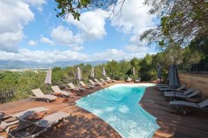 a swimming pool with lounge chairs and umbrellas at Le San Lorenzo in Porto-Vecchio