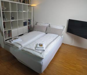 a white bed in a room with a book shelf at ruhige Terrassen-Whg. 68qm im Stadtzentrum (bis 5 Personen) checkin123 in Wiesbaden