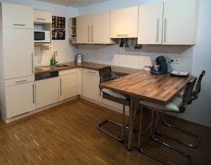 eine Küche mit einem Holztisch und weißen Schränken in der Unterkunft ruhige Terrassen-Whg. 68qm im Stadtzentrum (bis 5 Personen) checkin123 in Wiesbaden