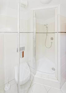 a white bathroom with a shower and a toilet at Múzeum Červený Kláštor in Červený Kláštor