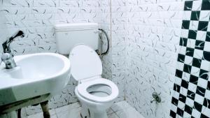La salle de bains est pourvue de toilettes blanches et d'un lavabo. dans l'établissement The Shivay Guest House, à Varanasi