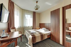 a hotel room with a bed and a table at POKOJE GOŚCINNE MAC-TUR in Gdańsk
