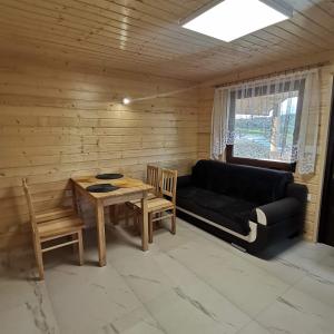 ein Wohnzimmer mit einem Sofa und einem Tisch in der Unterkunft Bieszczadzkie domki in Bukowiec