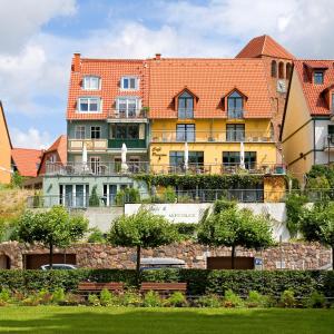 瓦倫的住宿－Pension Müritzblick，红色屋顶的大型黄色建筑
