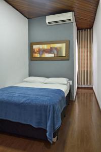 una camera da letto con un letto con una coperta blu di HOTEL SENADoR a Ribeirão Preto