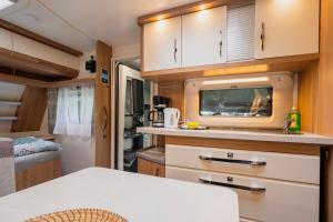 an rv kitchen with a sink and a microwave at Ferienpark Bad Sonnenland in Moritzburg