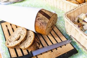 a loaf of bread on a cutting board with a knife at Hotel Gromada Pila in Piła