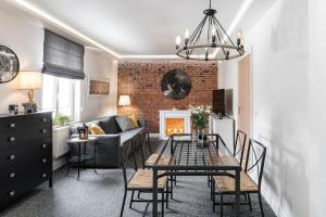 ソポトにあるSanhaus Apartments - Apartamenty Toledo - 3 minuty od plażyのリビングルーム(ソファ、テーブル、椅子付)
