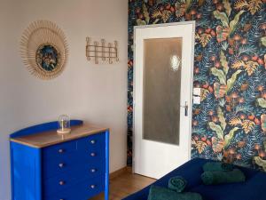 Zimmer mit blauer Kommode, blauem Schrank und Tür in der Unterkunft Lumineux Studio 30m² sur Cour - Proche Tram/Centre in Nantes