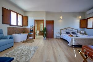 a bedroom with a bed and a tub and a bathroom at Dùplex Argollas Grand Suite Centro Parking gratis in Plasencia
