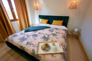 a bed with a tray with a plate of food on it at Casa de las Argollas Dúplex Grand Suite in Plasencia
