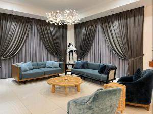 un soggiorno con divani blu e lampadario a braccio di La Villa Langkawi - Private Pool a Pantai Cenang