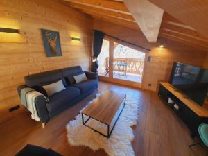 a living room with a couch and a coffee table at Chalet Delphinette - Spa privatif in Morzine