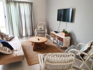a living room with a couch and a table and chairs at Acacia Four Seven Self-Catering in Swakopmund +7 photos
