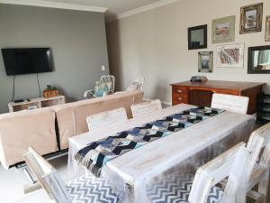 a living room with a table and a couch at Acacia Four Seven Self-Catering in Swakopmund
