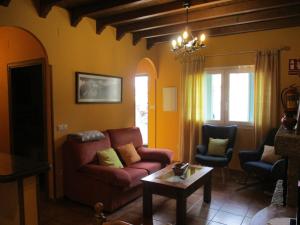een woonkamer met een bank en 2 stoelen bij Casa Rural Fuente Tía Canora in Solosancho