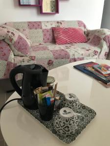 a coffee table with a tea pot on a table with a couch at Casa Mia in Néfiach