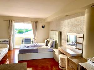 a bedroom with a bed and a couch and a mirror at Modern waterfront apartment with Miami Skyline view, free parking 5 mins drive to Miami Beach in Miami Beach
