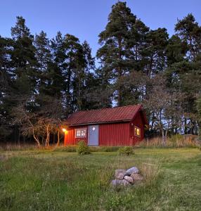 a red barn in the middle of a field at Stubbhuggets Lillstuga in Trosa